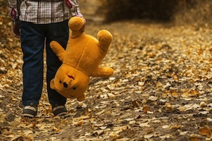 Autism reversed - photo of child carrying teddy upside down